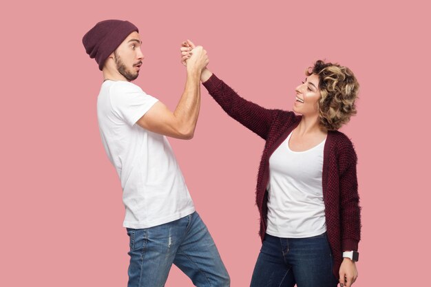 Foto retrato de una mujer joven con los brazos levantados de pie contra un fondo rosa