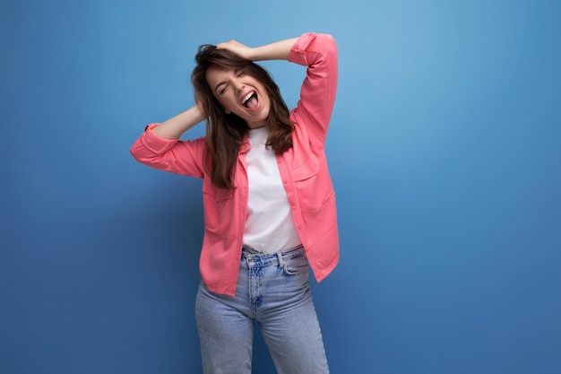 Retrato de mujer joven de cabello oscuro con estilo con sonrisa de hollywood aislado con fondo de estudio