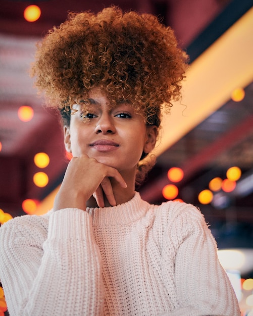 Retrato de una mujer joven con el cabello rizado en un restaurante