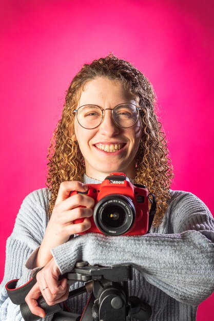 Foto retrato de una mujer joven con una cámara