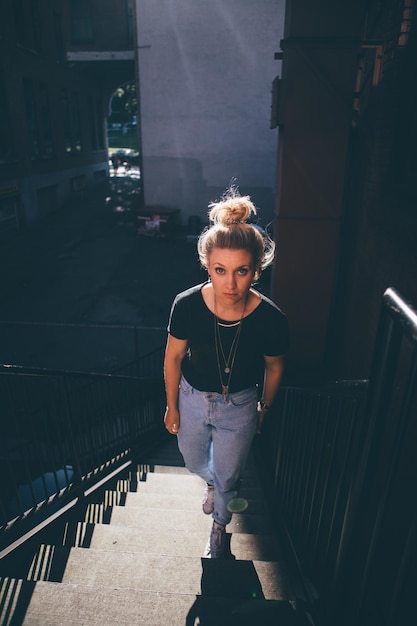 Retrato de una mujer joven caminando por las escaleras de la ciudad