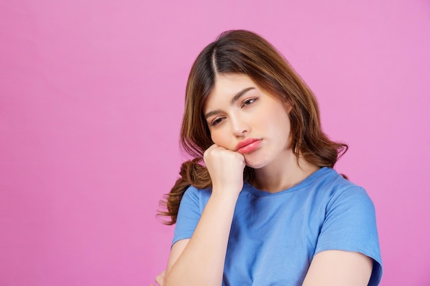 Retrato de mujer joven con camiseta casual pensando e imaginando aislado sobre fondo de color rosa