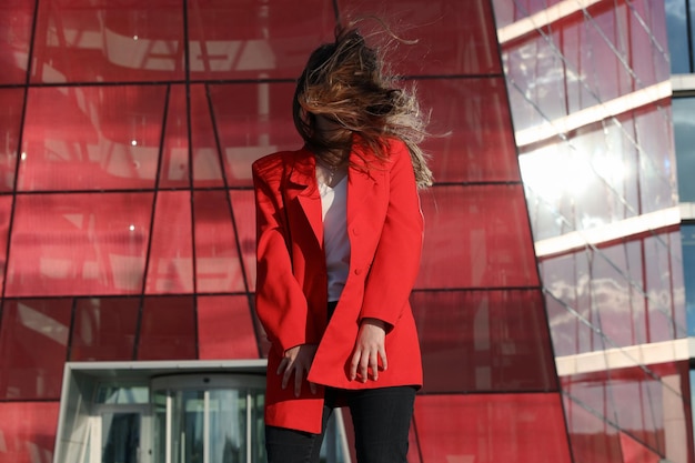 Retrato de una mujer joven con una chaqueta roja cuyo cabello cubría su rostro Retrato de verano