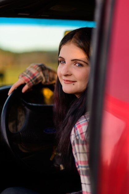 Foto retrato de una mujer joven en un coche rojo