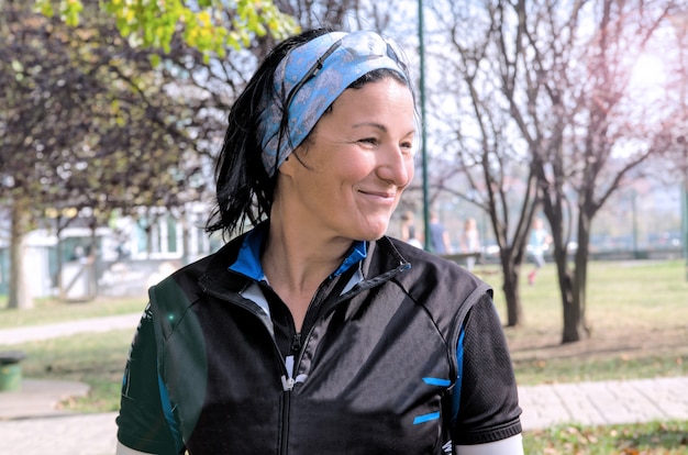 Retrato de mujer joven corredor en el parque. Deportes mujer de mediana edad sonriendo