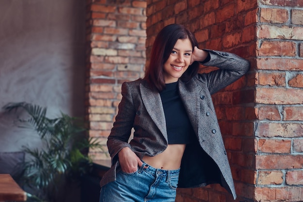 Retrato de una mujer joven delgada sexy en una chaqueta y jeans leani