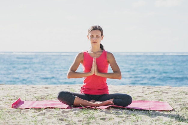 Retrato de mujer joven deportiva haciendo meditación al aire libre