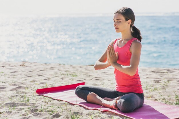 Retrato de mujer joven deportiva haciendo meditación al aire libre