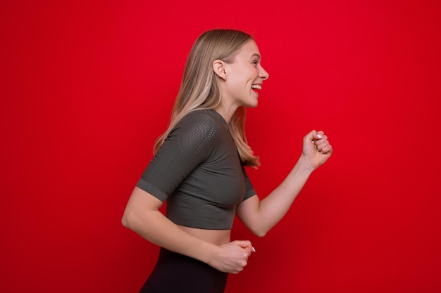 Retrato de una mujer joven deportiva sobre un fondo rojo.