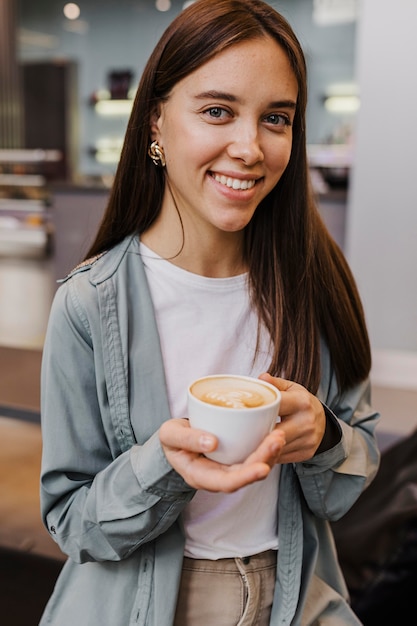 Retrato de una mujer joven disfrutando de un café