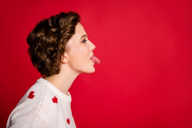 Retrato de una mujer joven con elegante puente de moda aislado en la pared roja