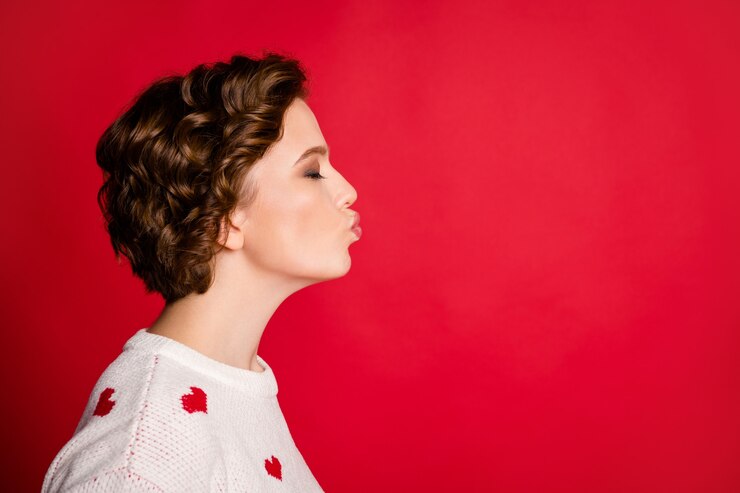 Retrato de una mujer joven con elegante puente de moda aislado en la pared roja