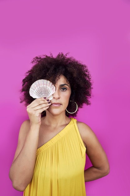 Retrato de una mujer joven, ella sostiene una concha en sus manos.