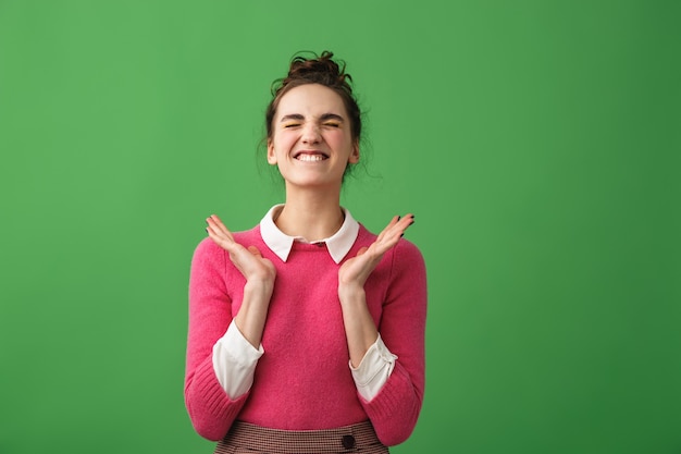 Foto retrato de una mujer joven emocionada gritando aislado sobre verde