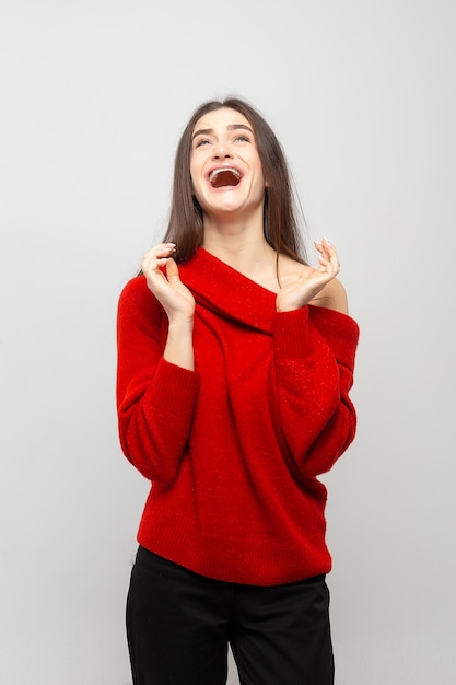 Retrato de una mujer joven con emociones positivas brillantes sobre un fondo gris claro La foto se ríe de las niñas