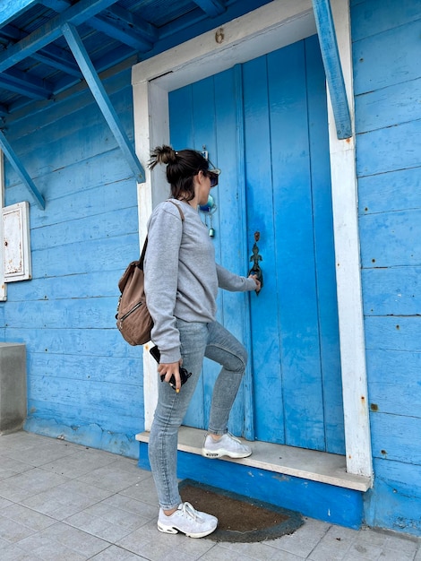 Foto retrato de una mujer joven entrando en una de las casas famosas de costa nova portugal
