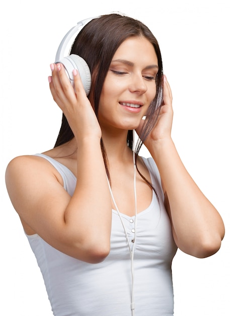 Retrato de una mujer joven escuchando música con auriculares