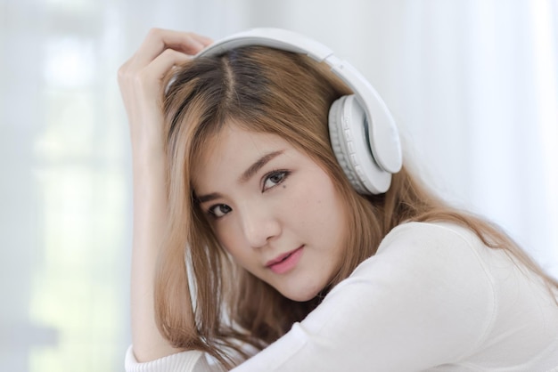 Retrato de una mujer joven escuchando música en casa