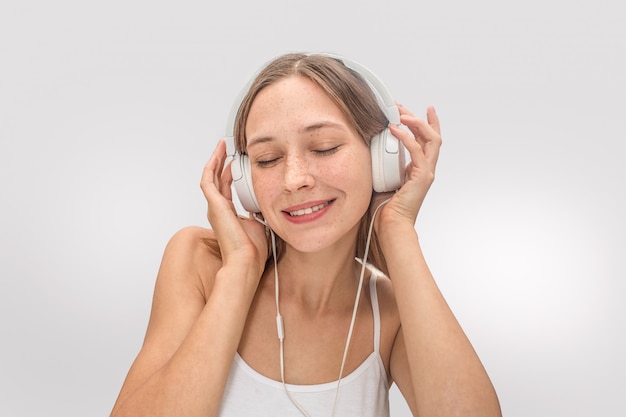 Retrato de mujer joven escuchando música.