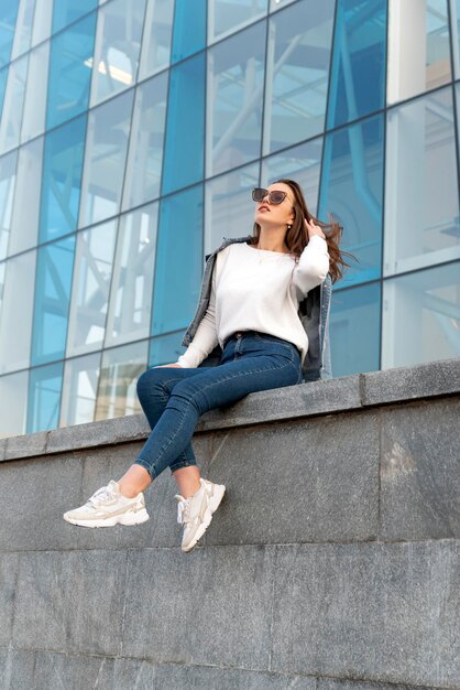 Retrato de mujer joven con estilo en gafas de sol en la calle de la ciudad