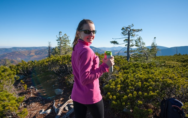 Retrato de mujer joven excursionista con taza de té