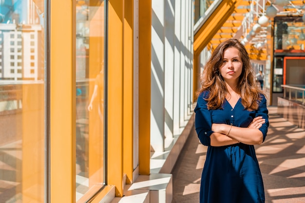 Retrato de una mujer joven exitosa en un espacio moderno y luminoso en el puente peatonal amarillo