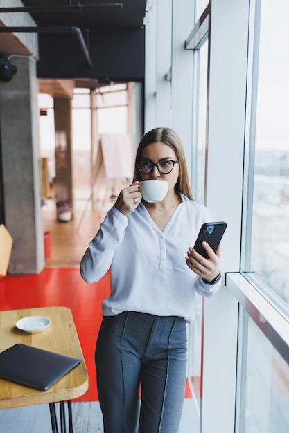 Retrato de una mujer joven y exitosa que resuelve problemas de negocios durante una conversación telefónica sentada en un café moderno Lindo interior disfruta de su tiempo libre en el café
