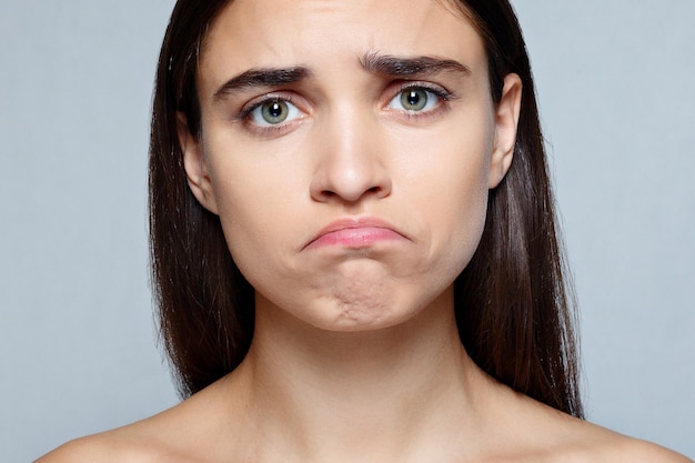 Retrato de mujer joven con expresión de tristeza conmocionada