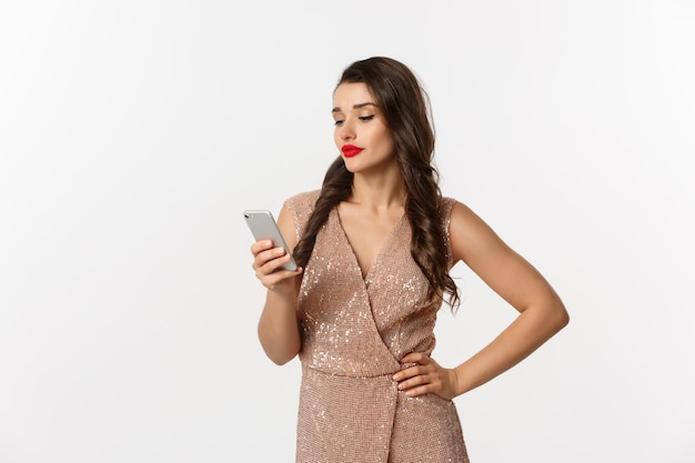 Retrato de mujer joven expresiva en elegante vestido con teléfono