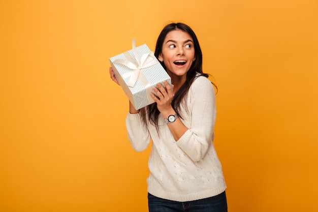 Retrato de una mujer joven feliz con caja de regalo