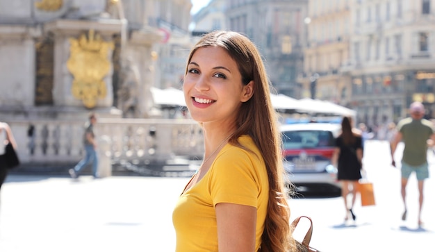 Retrato de mujer joven feliz caminando en la calle Graben, centro de la ciudad de Viena, Austria