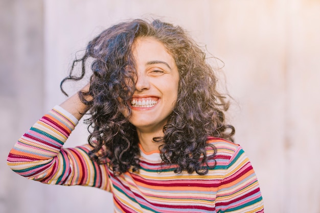 Retrato de una mujer joven feliz con el pelo rizado