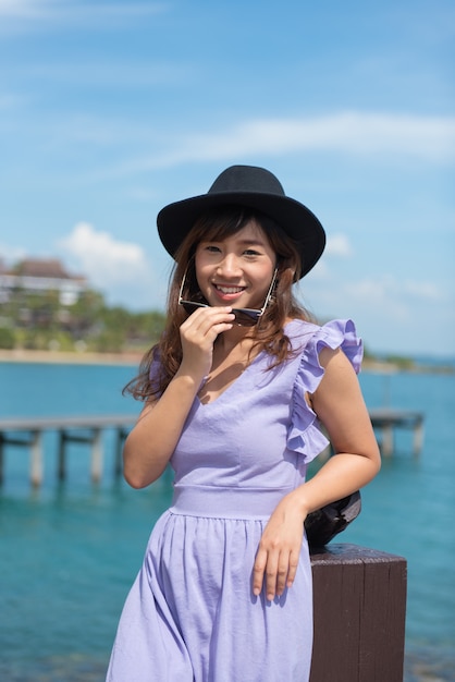 Foto retrato de la mujer joven feliz que sonríe en el mar en verano.