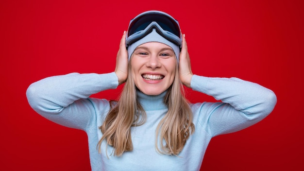 Retrato de una mujer joven feliz en un suéter y gafas de esquí