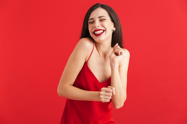 Retrato de una mujer joven feliz en vestido aislado, bailando