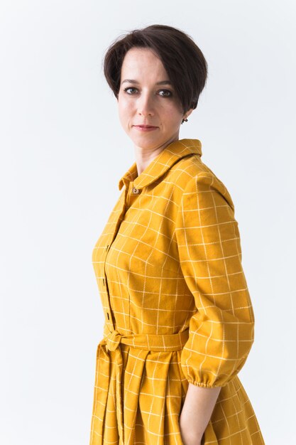 Retrato de una mujer joven feliz en vestido amarillo brillante