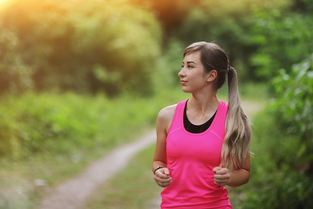 Retrato de mujer joven fitness en el bosque de la mañana. Vivir en forma saludable