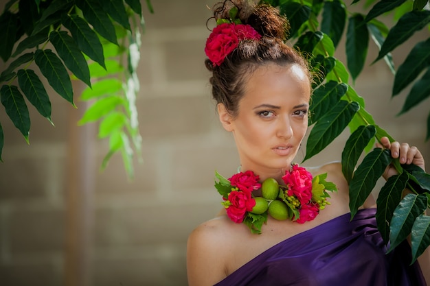 Retrato de una mujer joven con flores alrededor del cuello