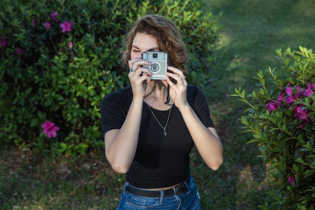 Foto retrato de una mujer joven fotografiando mientras está de pie al aire libre