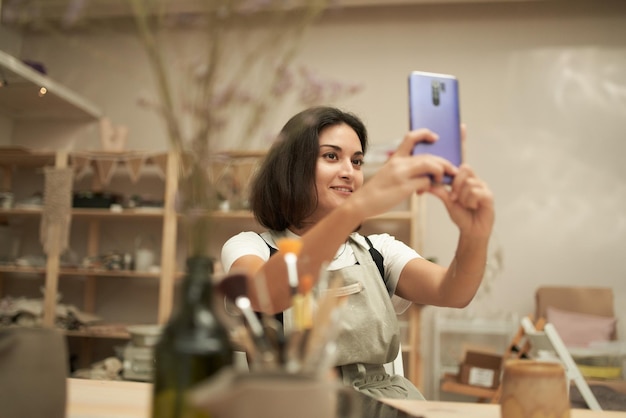 Foto retrato de una mujer joven fotografiando