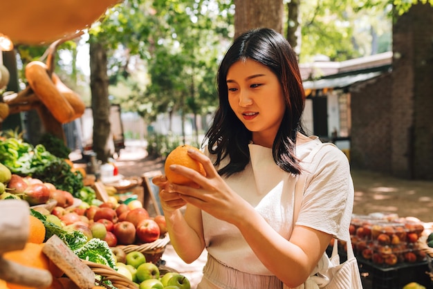 Retrato de una mujer joven con frutas en el mercado