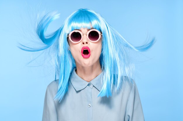 Retrato de una mujer joven con gafas de sol contra un fondo azul