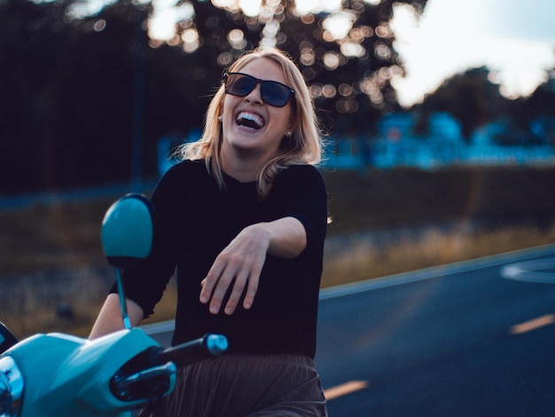 Foto retrato de una mujer joven con gafas de sol mientras está de pie contra el cielo