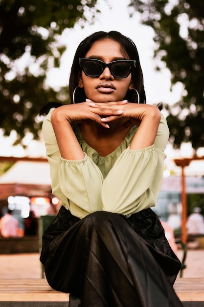 Retrato de una mujer joven con gafas de sol de pie al aire libre