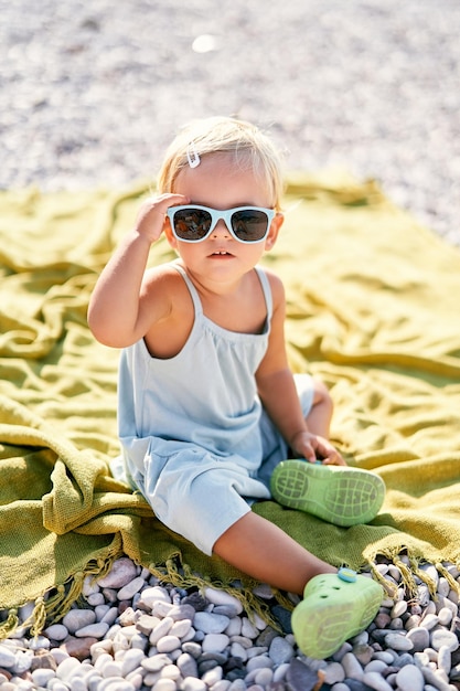 Retrato de una mujer joven con gafas de sol en la playa