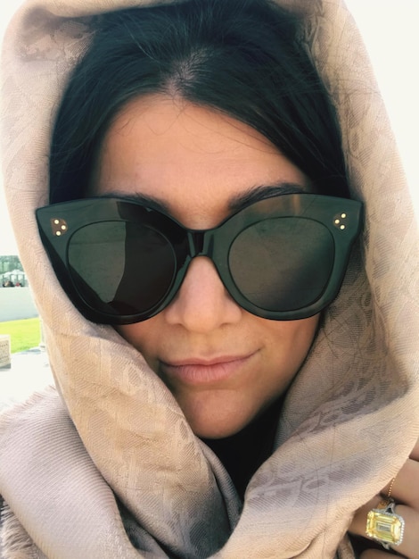 Foto retrato de una mujer joven con gafas de sol