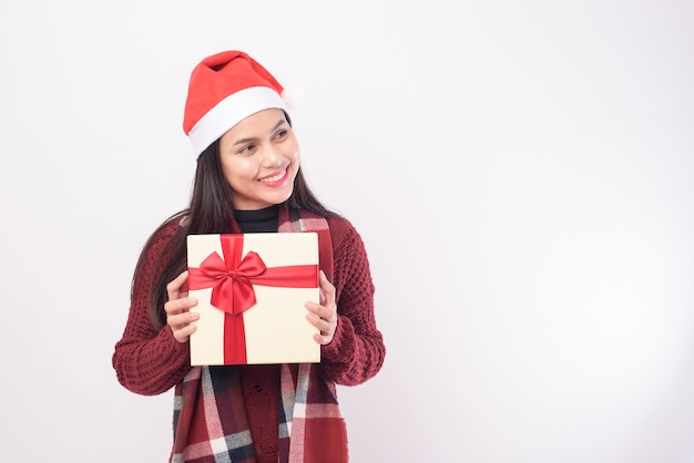 Un retrato de mujer joven con gorro de Papá Noel rojo aislado con caja de regalo