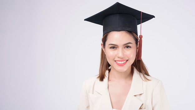 Retrato de mujer joven graduada sobre fondo blanco.