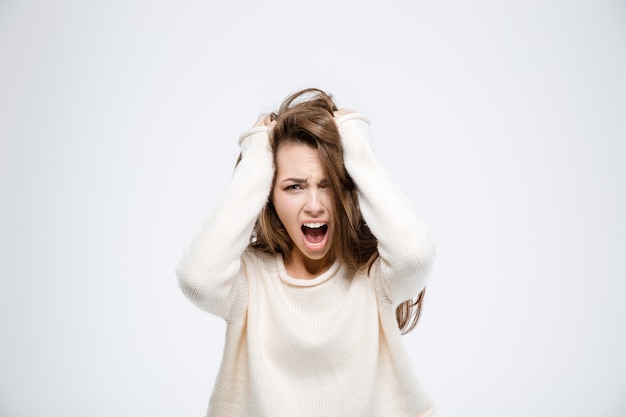 Retrato de una mujer joven gritando aislado sobre un fondo blanco.