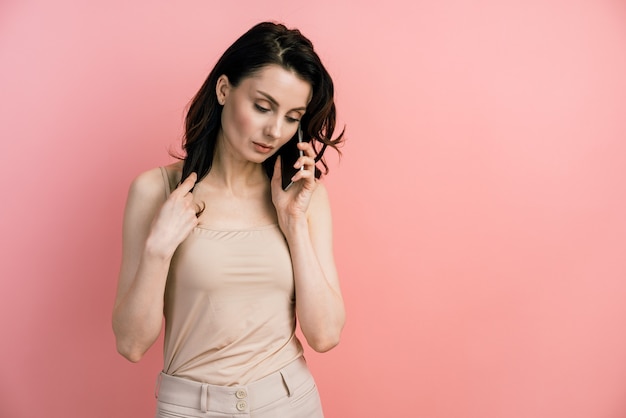 Retrato de una mujer joven hablando por un teléfono móvil.